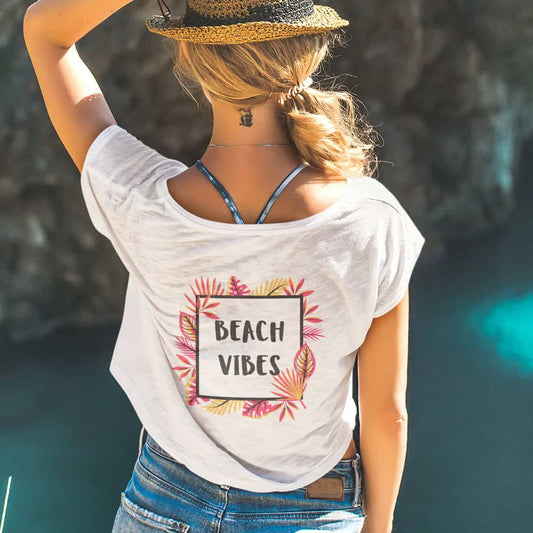 Rückenansicht eines jungen Mädchens die ein Croptop mit Beach Vibes-Design trägt.