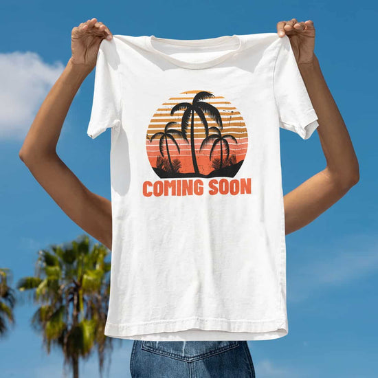 Blauer Himmel mit Palmen im Hintergrund, davor eine Frau die ein weißes TShirt hält mit der Aufschrift Coming Soon.