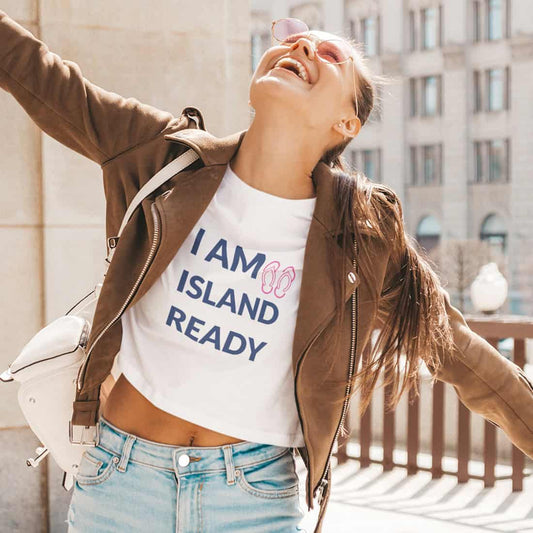 Junge Frau rosa Sonnenbrille, brauner Lederjacke, braunen langen Haaren und Zopf trägt ein weißes Crop Top mit Print.
