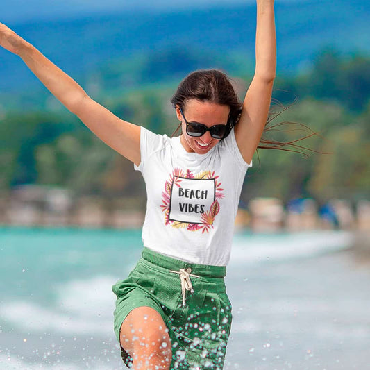 Tropischer Hintergrund und Tanz im tropischen Wasser beschreibt die Frau in grünen Shorts und einem weißen T-Shirt mit Print.