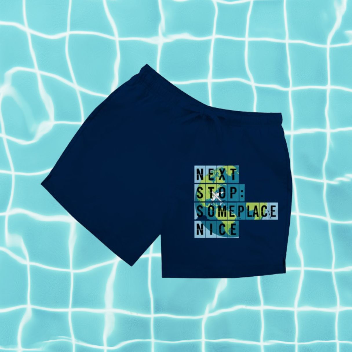 Dunkelblaue Herren Badeshorts mit Aufdruck „Next Stop Someplace Nice“ vor Poolwasser-Hintergrund.