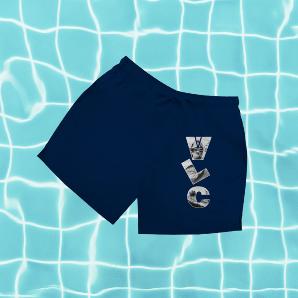 Dunkelblaue Herren Badeshorts mit Aufdruck „VLC“ (Airport-Code) vor Poolwasser-Hintergrund.