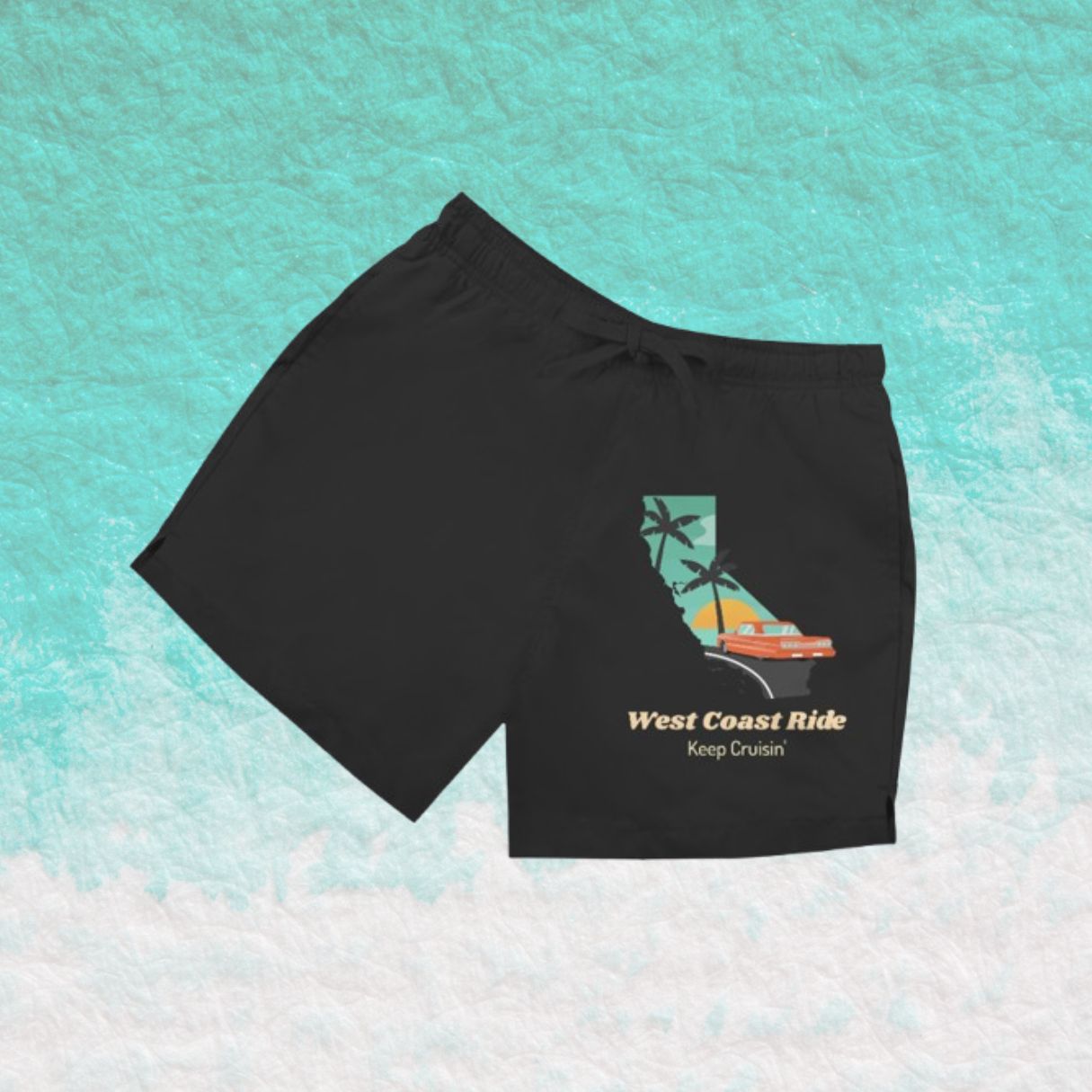 Schwarze Herren Badeshorts mit Schriftzug „West Coast Ride“ vor türkisfarbenem Wasserhintergrund.