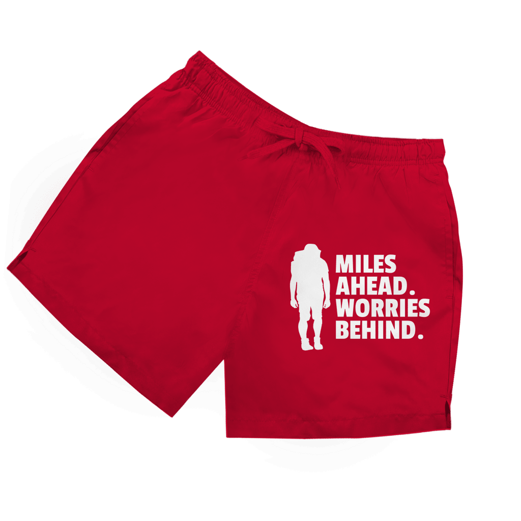 Rote Herren Badeshorts mit Wanderer-Silhouette und Schriftzug „Miles Ahead. Worries Behind.“ in weiss.