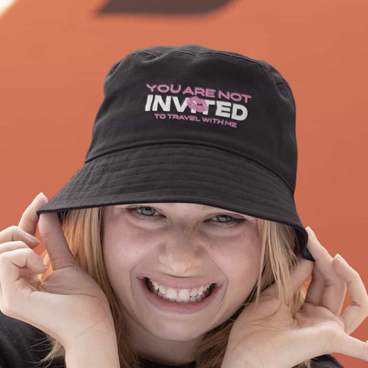 Unisex Fischerhut  in schwarz mit Design wird von junger Frau an beiden Seiten gehalten.