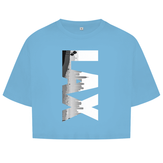 Hellblaues Oberteil mit dem Airport Code, vertikaler Druck. Über den 3 Buchstaben liegt als Bild die Skyline der Stadt.