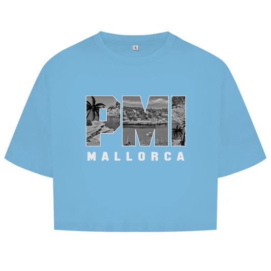 Hellblaues Oberteil mit dem Airport Code, horizontaler Druck. Als Overlay von PMI ein Bild mit Palmen, Boot und Küste.