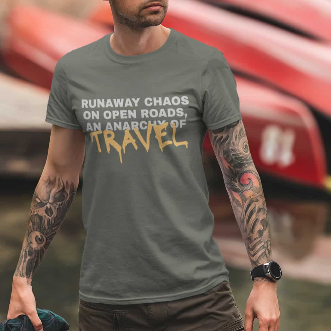 Junger Mann mit Tattoos trägt das TShirt RUNAWAY CHAOS in Urban Khaki zur Hose passend farbig beim Strandspaziergang.